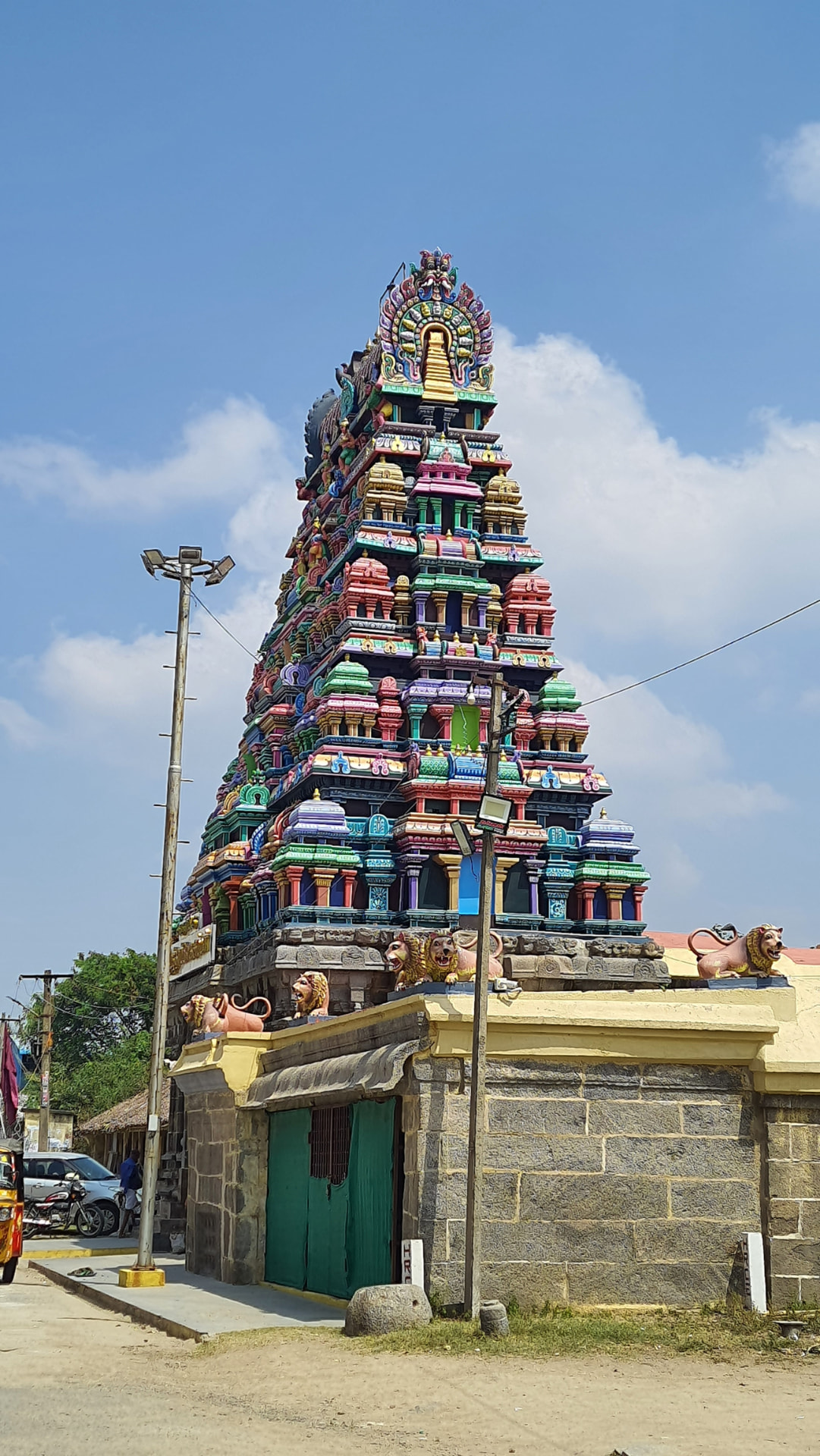Colorful sculpted gopuram rising above the stone entrance of a temple